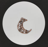 This Copper Moon Pendant is an enchanting piece accented with delicate Freshwater Pearls and Moonstones. The combination of these elements creates a celestial and feminine aesthetic that evokes a sense of mystery and beauty. The warm tones of the copper contrast beautifully with the iridescence of the Moonstone and the soft sheen of the pearls, making this pendant a striking accessory for any occasion.