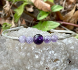 This elegant cuff bracelet is handcrafted from heavy gauge (.925) sterling silver, offering both strength and sophistication. It features a stunning combination of classic Amethyst and striking Dog Tooth Amethyst, showcasing rich purple hues and natural patterning. A powerful statement piece for crystal lovers and those who appreciate artisan silverwork.