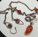 A carnelian leaf pendant rests on copper, accented with carnelian beads and delicate copper leaves — this necklace is a piece that feels alive, like autumn caught in motion.