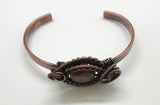 This Hand Woven Copper Cuff Bracelet with Cherry Creek Jasper is a striking piece of jewelry featuring a solid copper cuff with an intricately woven Cherry Creek Jasper centerpiece. This bracelet combines the warmth and durability of copper with the natural beauty of Cherry Creek Jasper, creating a unique and elegant accessory.