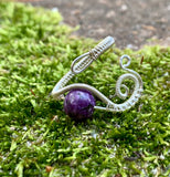 This Beautiful Purple Charoite and Hand Woven Sterling Silver Ring showcases a stunning charoite gemstone set in intricately hand-woven sterling silver. This ring combines the unique, vibrant hue of charoite with the elegance of sterling silver, creating a luxurious and eye-catching piece of jewelry.