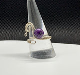 This Beautiful Purple Charoite and Hand Woven Sterling Silver Ring showcases a stunning charoite gemstone set in intricately hand-woven sterling silver. This ring combines the unique, vibrant hue of charoite with the elegance of sterling silver, creating a luxurious and eye-catching piece of jewelry.