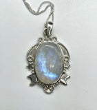 This enchanting pendant showcases a mesmerizing rainbow moonstone with an iridescent glow, set in a beautifully detailed sterling silver setting adorned with celestial stars and a crescent moon. Suspended on a 20" sterling silver chain, this piece captures the magic of the night sky, making it a perfect gift for dreamers and stargazers.