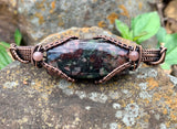 This Hand Woven Copper Bracelet with Candlelite and Purple Dumortierite Bead Accents is perfect for individuals who appreciate handcrafted, artisan jewelry with natural gemstones. It appeals to those who love earthy, rustic designs with a touch of elegance and vibrancy. The bracelet is ideal for those who seek unique, one-of-a-kind pieces that blend beauty and craftsmanship.