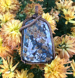 This Bold Flower Jasper Pendant in Copper features a striking and vibrant flower jasper stone set within a beautifully crafted copper frame. Known for its rich colors and intricate patterns, the flower jasper provides a dramatic focal point, while the copper setting enhances the pendant's natural beauty with a touch of artisanal elegance. This pendant is a statement piece that combines bold design with handcrafted quality.