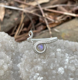 This stunning adjustable ring showcases a mesmerizing Australian Opal with a lovely purple flash, wire wrapped in Argentium Silver. Adjustable to fit a range of sizes, this ring combines elegance with practicality, making it both a statement piece and a comfortable, versatile accessory. The Argentium Silver ensures a bright, tarnish-resistant finish, perfect for showcasing the Opal's magical colors. A true one-of-a-kind treasure!
