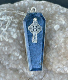 This captivating necklace features a deep blue Dumortierite stone, expertly shaped into a coffin design and set in sterling silver. The pendant is adorned with an intricate Celtic cross, symbolizing unity and eternal life. The contrast between the rich tones of the Dumortierite and the sleek sterling silver adds depth and elegance, making this piece perfect for those who appreciate symbolic, gothic-inspired jewelry with a touch of timeless craftsmanship.