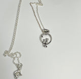 This delightful necklace features two miniature Sterling Silver cats under a crescent moon, evoking a sense of whimsy and wonder. Perfectly detailed, the pendant is both playful and elegant, making it an ideal gift for cat lovers and dreamers alike. Suspended on a 20" Sterling Silver chain, this necklace adds a touch of charm to any outfit.