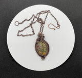 Colorful Picasso Jasper Necklace in green, brown and yellow surrounded by multiple copper weaves and coils. 