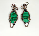 These handcrafted earrings feature rich green malachite stones wrapped in a combination of square and twisted square copper wire, adding depth and dimension to the design. The swirling bands of the malachite beautifully complement the warm copper tones, while hypoallergenic niobium ear wires ensure all-day comfort. A perfect blend of bold elegance and natural beauty—ideal for everyday wear or special occasions.