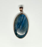 This bold pendant showcases a striking blue labradorite with vibrant flashes of color that dance in the light. Set in copper, the design enhances the stone’s natural iridescence and mystical appeal. A powerful statement piece, perfect for those drawn to the magic of labradorite.