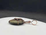 This enchanting pendant features a Copper owl set over Golden Sheen Obsidian, known for its mysterious dark surface with shimmering gold undertones. Hand-wrapped in warm copper wire, the design highlights the owl’s wise, mystical presence and the stone’s natural glow. A perfect piece for nature lovers, night owls, and anyone who enjoys a touch of magic in their jewelry.