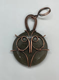 This enchanting pendant features a Copper owl set over Golden Sheen Obsidian, known for its mysterious dark surface with shimmering gold undertones. Hand-wrapped in warm copper wire, the design highlights the owl’s wise, mystical presence and the stone’s natural glow. A perfect piece for nature lovers, night owls, and anyone who enjoys a touch of magic in their jewelry.