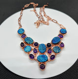 This dazzling necklace features shimmering titanium druzy paired with rich purple Amethyst, all set in warm copper. Brilliant flashes of blue and purple create an eye-catching piece full of sparkle and personality.