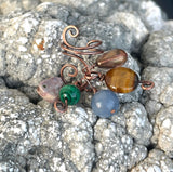 Hammered Copper Ear Cuff with 5 interchangeable dangles.&nbsp; Comes with a Jasper Heart, a faceted Tiger Eye, a Crystal bead dangle, a Malachite bead dangle and a Dumortierite bead dangle. Wear one, none or all, it's like 6 earrings in one! This was designed to be worn on the left ear. 