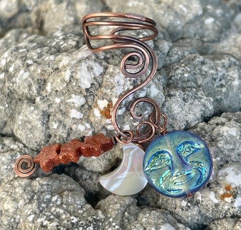 Hammered Copper Ear Cuff with 3 interchangeable celestial dangles.&nbsp; Comes with Goldstone stars dangle, an iridescent Glass full moon dangle&nbsp; and a Mother of Pearl half moon dangle. Wear one, none or all three, it's like 4 earrings in one! This was designed to be worn on the left ear. 