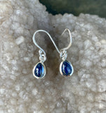 These elegant earrings showcase beautiful Blue Kyanite stones set in Sterling Silver. The deep, vibrant blue of the Kyanite contrasts beautifully with the sleek, polished silver, creating a sophisticated and timeless look. The earrings offer a touch of refined elegance and are perfect for adding a pop of color to any ensemble.