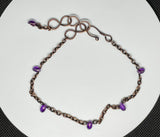 This charming adjustable ankle bracelet combines the warm glow of copper with the vibrant hues of purple Czech glass beads. The design features a delicate balance of color and texture, with the copper providing a sturdy yet flexible base and the Czech glass beads adding a touch of sparkle. The adjustable feature ensures a perfect fit for any ankle, making it a versatile and stylish accessory.