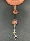 This Large Irish Flat Scallop Shell Sun Catcher features a beautifully natural Irish flat scallop shell adorned with woven copper wire, glass beads, crystals, and a starfish dangle. This sun catcher is designed to capture and reflect light, creating a shimmering and decorative effect.