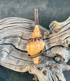 This unique Horse Shell Conch Pendant showcases a natural shell that has been hand-collected and transformed into a wearable piece of art. Encased in handwoven copper wire with copper bead accents, the pendant beautifully blends the organic texture of the shell with the warm tones of copper. This piece celebrates nature and craftsmanship, making it a truly one-of-a-kind accessory that holds both personal and aesthetic value.