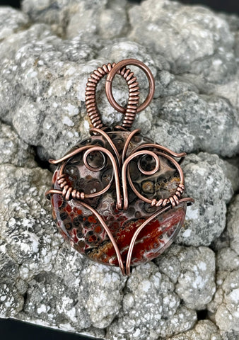 This unique pendant features a beautifully patterned Leopard Skin Jasper stone, nestled within a hand-sculpted copper owl design. The earthy tones and intricate patterns of the Jasper mirror the natural beauty of the wise owl, symbolizing wisdom and intuition. The copper detailing enhances the organic feel of the piece, making it a charming and meaningful accessory for nature lovers or those drawn to mystical symbolism.