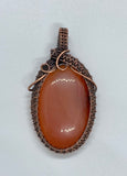 Striking striped natural salmon colored Agate Pendant wrapped in handwoven copper.
