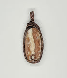 Natural Agate Pendant with flowing rivers of white and pink inside, wrapped in handwoven copper. 