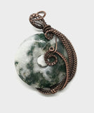 This reversible pendant features a 35mm Moss Agate Donut with a Moss agate bead in the center wrapped in copper.