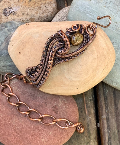 Woven Copper surrounds this Bronzite bead in this one of a kind handmade adjustable bracelet.