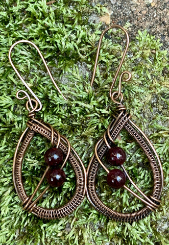 Handwoven Copper Earrings with beautiful African Garnets hang from handmade copper ear wires.