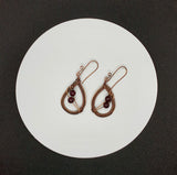 Handwoven Copper Earrings with beautiful African Garnets hang from handmade copper ear wires.