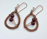 Handwoven Copper Earrings with beautiful African Garnets hang from handmade copper ear wires.