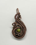 This Pendant has layers of handwoven copper and coiled copper surrounding a beautiful green Serpentine. 