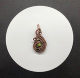 This Pendant has layers of handwoven copper and coiled copper surrounding a beautiful green Serpentine. 