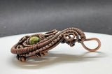 This Pendant has layers of handwoven copper and coiled copper surrounding a beautiful green Serpentine. 