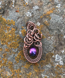 This Woven Copper and Copper Swirls Accent Rainbow Colored Glass Bead Pendant is an eye-catching piece of jewelry that combines a&nbsp;vibrant rainbow-colored glass bead with the warm and earthy tones of woven copper. The intricate copper swirls and handcrafted wirework enhance the pendant’s charm, creating a beautiful fusion of bold colors and artisan craftsmanship.