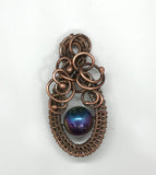 This Woven Copper and Copper Swirls Accent Rainbow Colored Glass Bead Pendant is an eye-catching piece of jewelry that combines a&nbsp;vibrant rainbow-colored glass bead with the warm and earthy tones of woven copper. The intricate copper swirls and handcrafted wirework enhance the pendant’s charm, creating a beautiful fusion of bold colors and artisan craftsmanship.