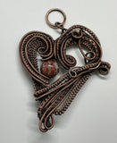 This Heart Pendant features layers of handwoven copper weaves and coils and a Leopard Skin Jasper Bead Accent. 