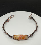 Sunny orange Striped Agate bracelet with copper weaves and swirls. Adjustable. 