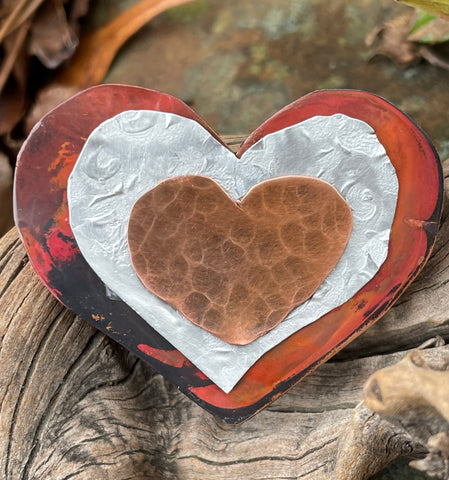 This heart pin is made of red patinated Copper, embossed Aluminum and a hammered Copper Heart on top.