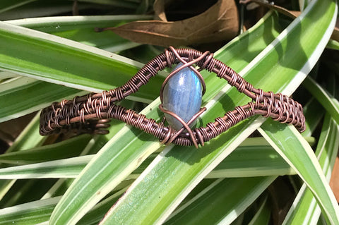 This adjustable bracelet showcases a mesmerizing marquise-shaped Labradorite cabochon, wrapped in warm, handwoven copper. The Labradorite's enchanting flashes of color catch the light beautifully, making this piece a standout addition to any jewelry collection. With its adjustable design, this bracelet ensures a comfortable fit while blending elegance with everyday wearability.