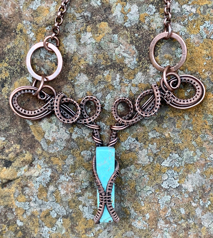 Handwoven Copper weaves capture a Chrysocolla spike then curl and swirl around each other in this one of a kind necklace. 