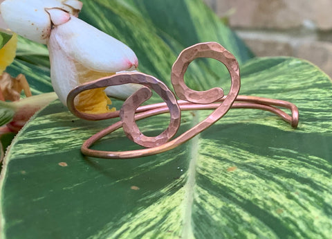 This striking bracelet is crafted from heavy gauge copper that has been expertly annealed and hammered, creating a unique texture that catches the light beautifully. The organic design showcases the rich warmth of copper, making it a standout piece in any jewelry collection. Comfortable and lightweight, this bracelet is a true testament to the beauty of handcrafted jewelry.