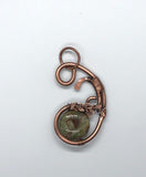 This Rainforest Jasper Bead Pendant showcases a striking rainforest jasper gemstone surrounded by heavy gauge copper, hammered to perfection and adorned with a copper leaves accent. The earthy tones of the jasper, with its natural green, brown, and gold patterns, perfectly complement the warmth of the copper. The addition of hand-shaped copper leaves enhances the organic theme of the pendant, creating a piece that is both elegant and nature-inspired.