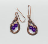 Handwoven Copper Teardrops with Amethyst accents hang from handmade copper ear wires. in these earrings