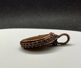Red Fossilized Dinosaur Bone Cabochon Pendant wrapped in handwoven copper.