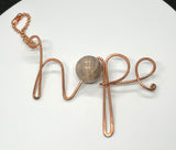 This unique keychain features the word "hope" elegantly hammered into heavy gauge Copper. The hammered texture gives it a rustic and handmade charm. A large, glowing Sunstone bead adds warmth and vibrancy to the design, complementing the copper's natural tones. This keychain serves as a thoughtful reminder of positivity and resilience, while its sturdy construction ensures durability. Perfect for carrying a bit of hope wherever you go!