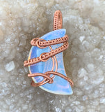 This Opalite Moon Pendant wrapped in Handwoven Copper is a beautifully crafted pendant that marries the mysticism of the moon with the earthy warmth of copper. Its celestial symbolism, glowing Opalite stone, and intricate copper weaving make it a unique and enchanting accessory, perfect for anyone who appreciates handmade, nature-inspired jewelry.