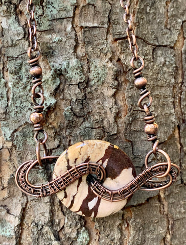 Brown Zebra Jasper Donut wrapped in handwoven copper to create this unique necklace with copper bead accents.