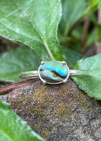 This exquisite ring features a vibrant Paua Shell, known for its stunning iridescent blues and greens, set in sleek sterling silver. The natural beauty of the Paua Shell’s swirling colors is perfectly complemented by the silver, creating a harmonious and eye-catching design. Ideal for those who love unique, ocean-inspired jewelry, this ring is a beautiful statement piece that adds a touch of elegance and nature’s beauty to any outfit.